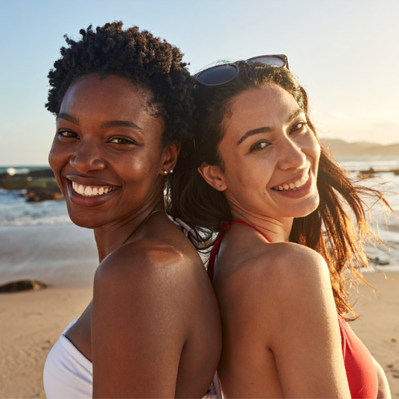 TWG Hero Image Two women smiling while at the beach.