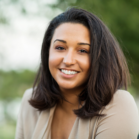 Well Woman Exam Smiling woman with shoulder-length dark hair standing outdoors